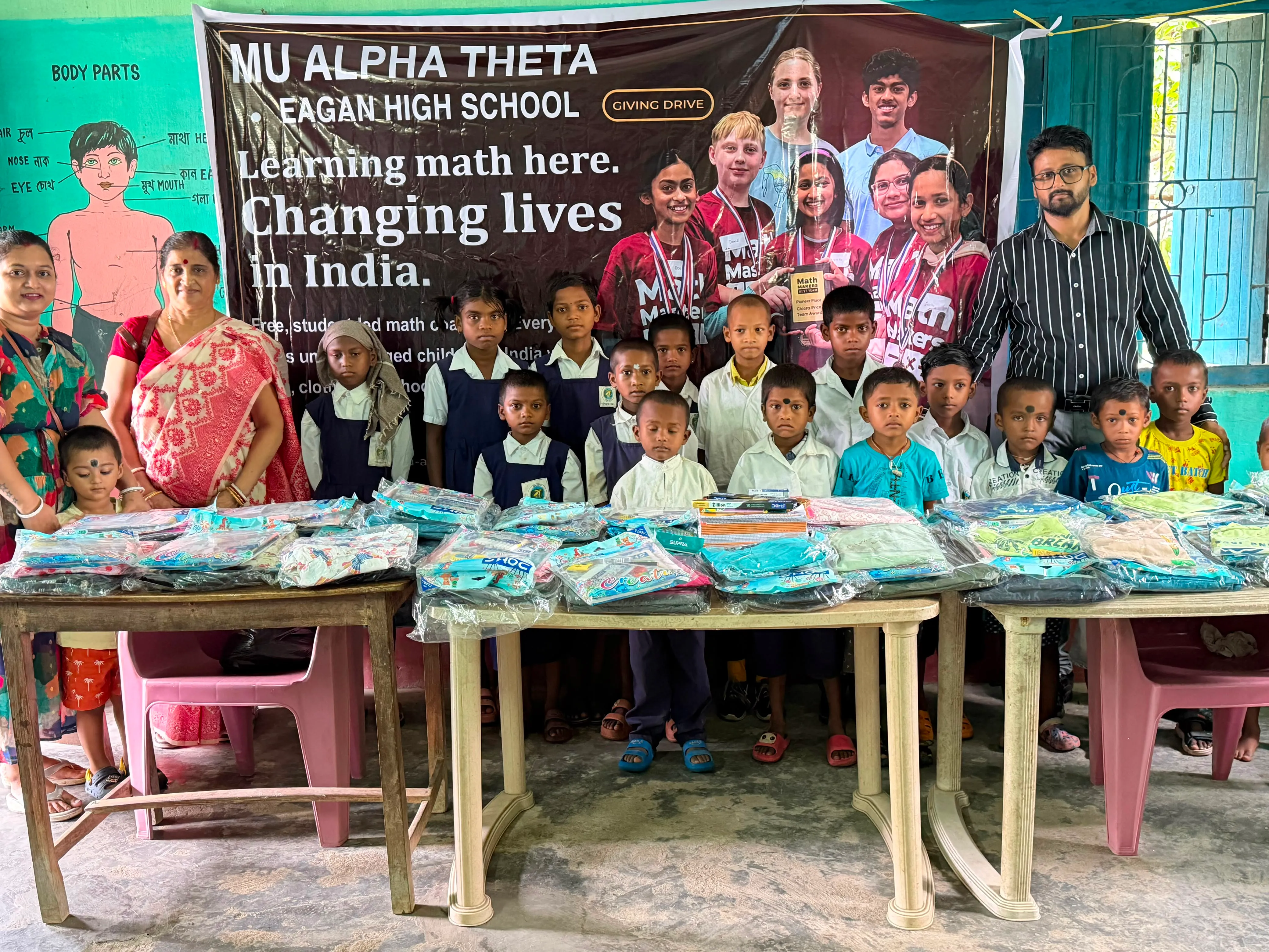 A volunteer hands school supplies to a student