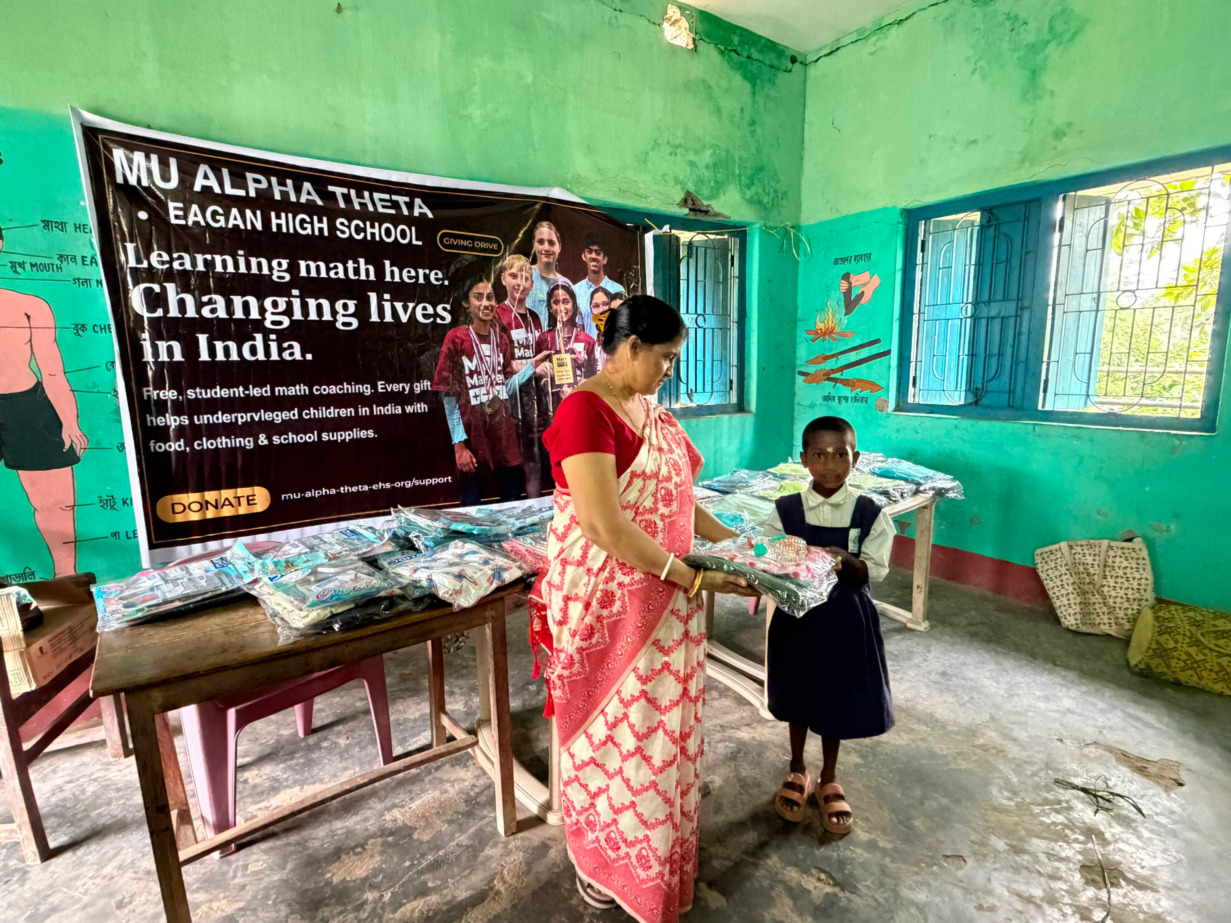 Students and families gather with our team banner at the Giving Drive in West Bengal